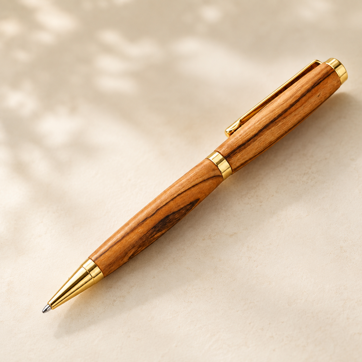 Close product view of natural Bethlehem olive wood pen grain and gold-tone hardware