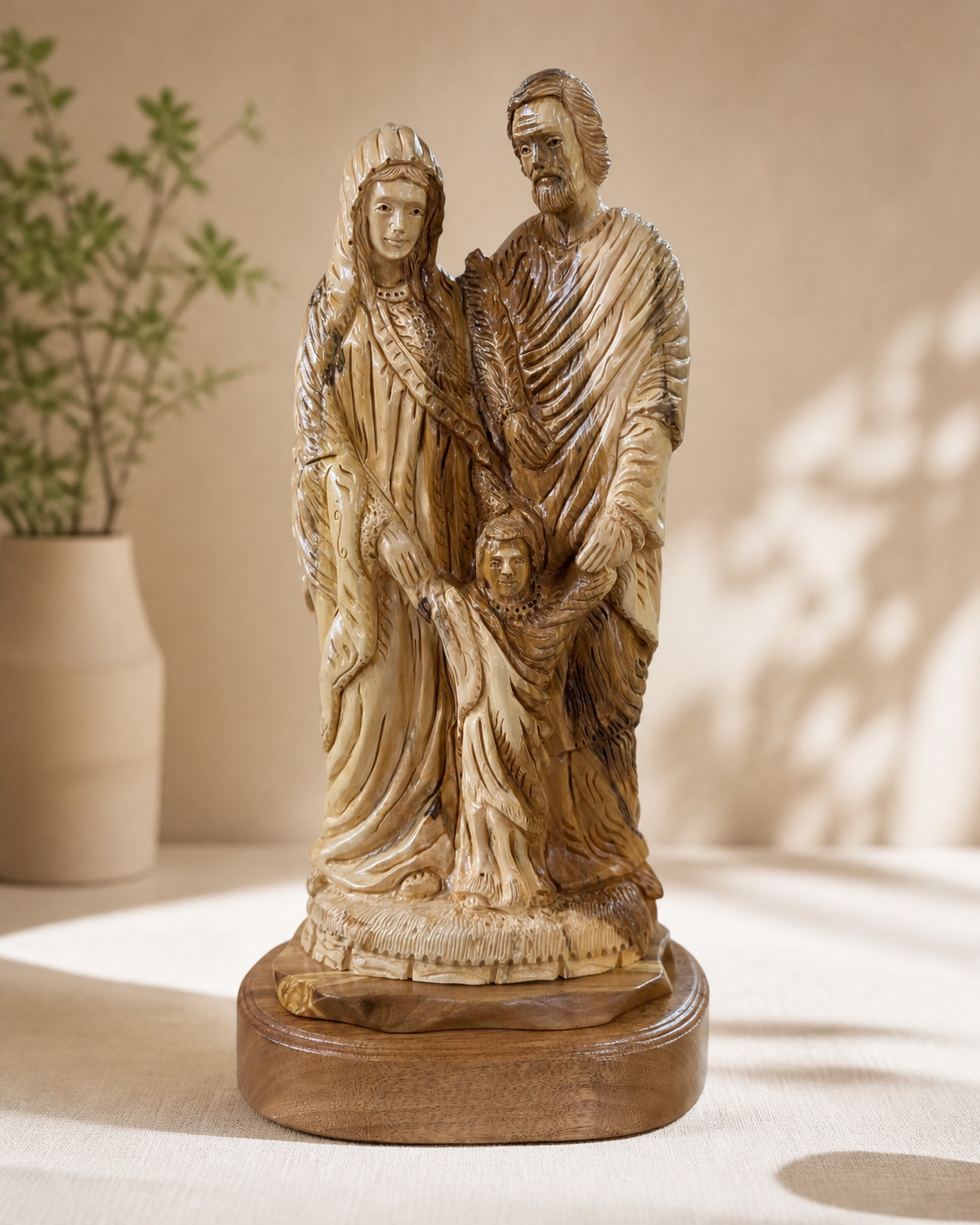 Holy Family olive wood carving displayed in a softly lit home interior