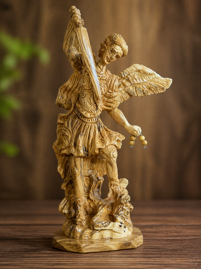 St. Michael olive wood sculpture photographed against a warm wood backdrop