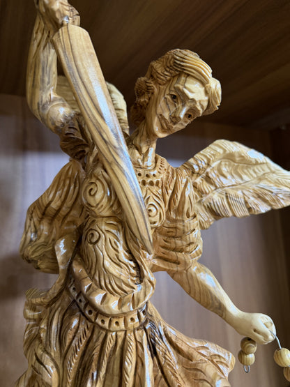 Close view of the carved face and armor on the St. Michael olive wood statue