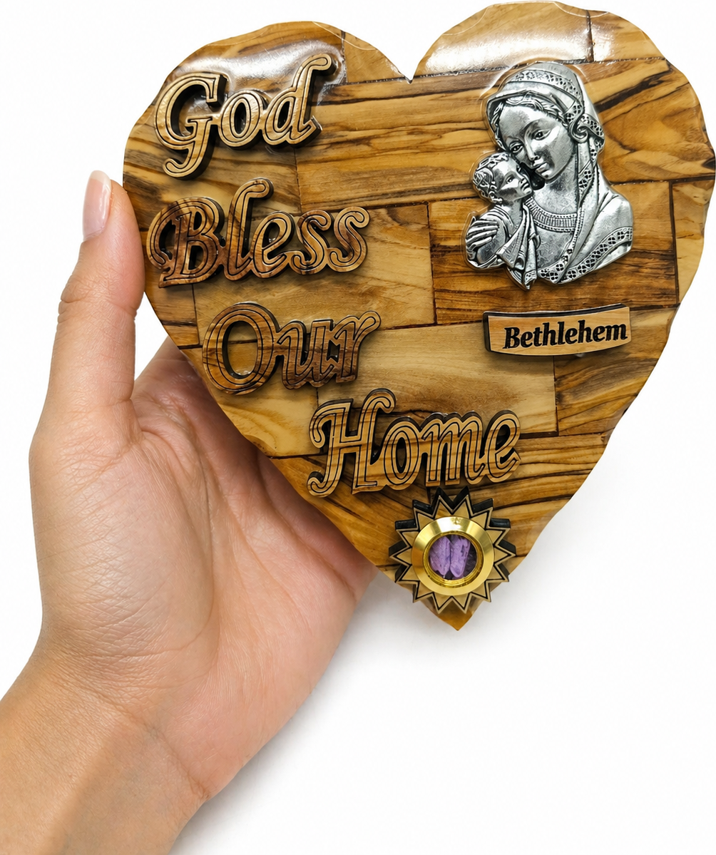 Olive wood God Bless Our Home heart plaque held in hand showing 6.4 inch palm size from Bethlehem workshop