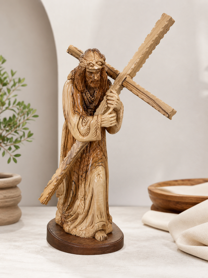 Jesus carrying the cross statue shown against a light architectural background