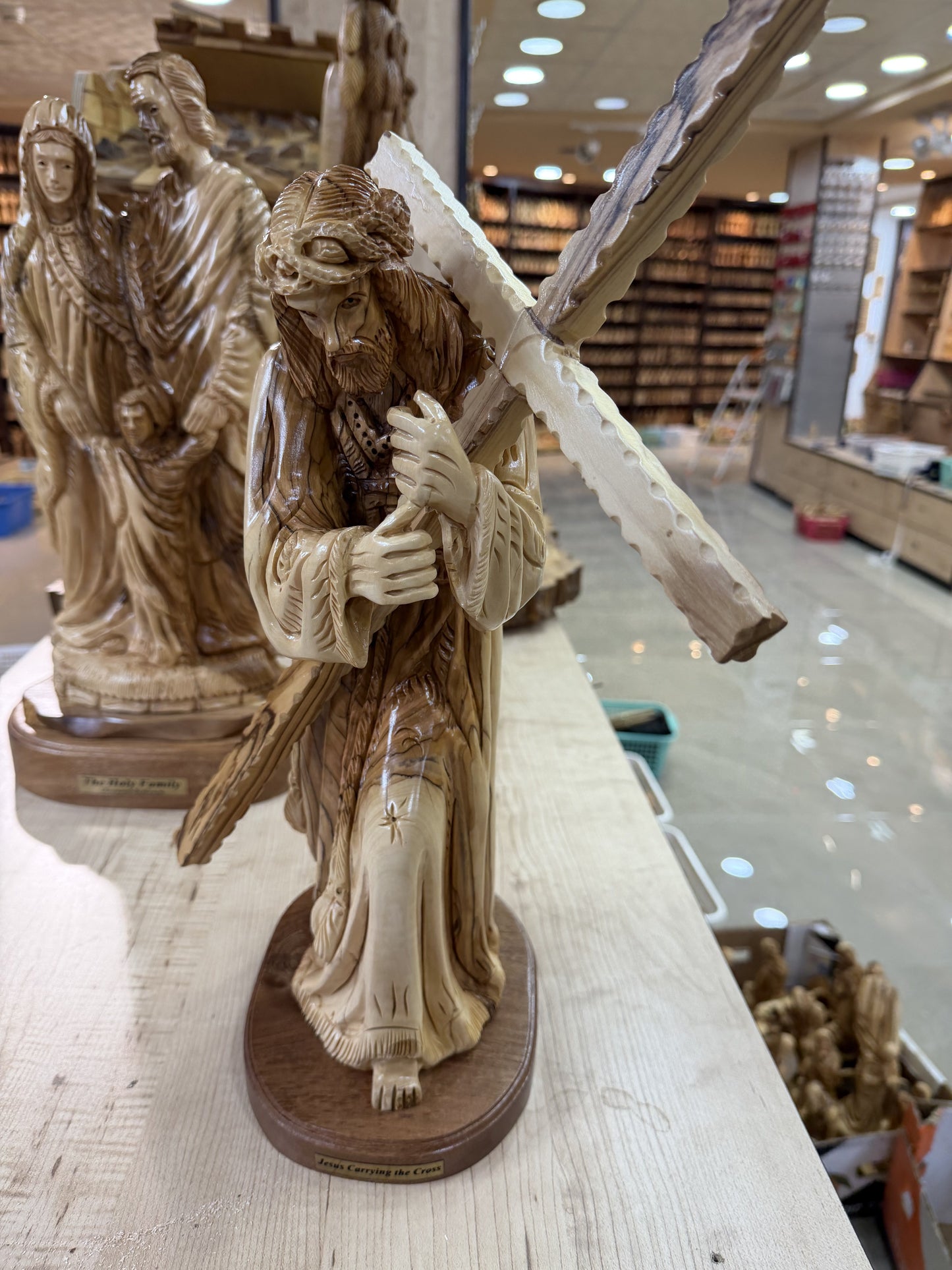 In-hand scale view of the substantial Jesus carrying the cross sculpture