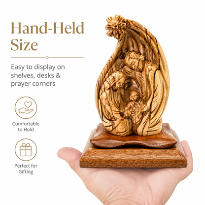 Olive wood Nativity scene held in a hand, showing the 8 inch hand held size