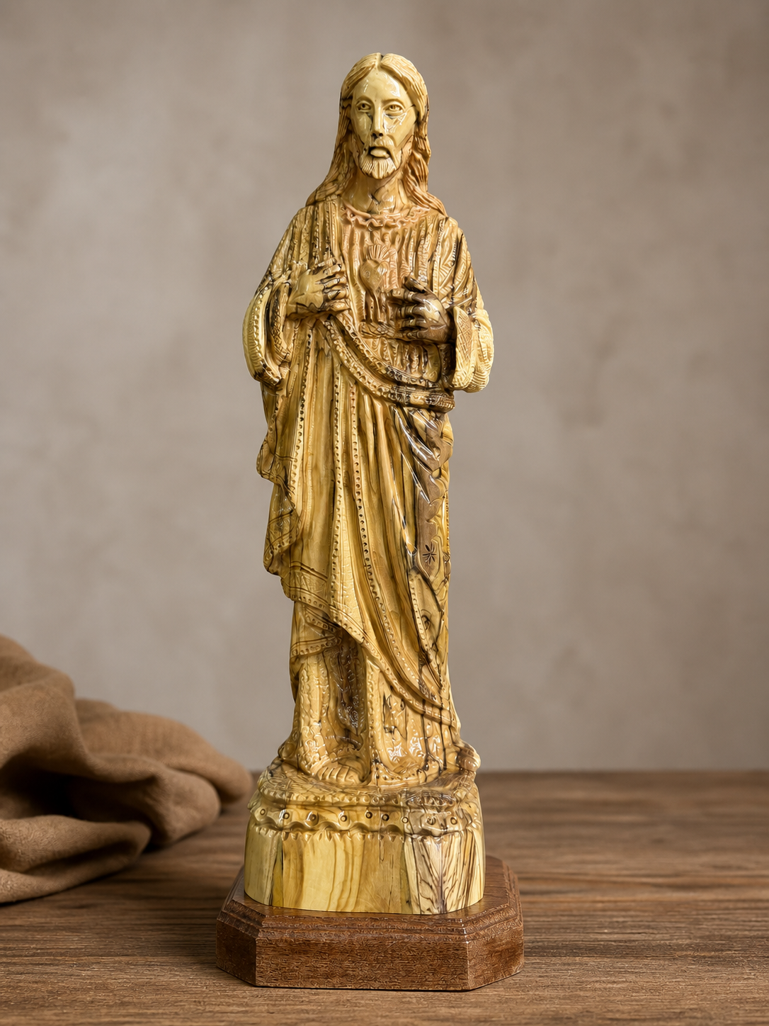 Sacred Heart of Jesus olive wood statue displayed in a calm neutral interior