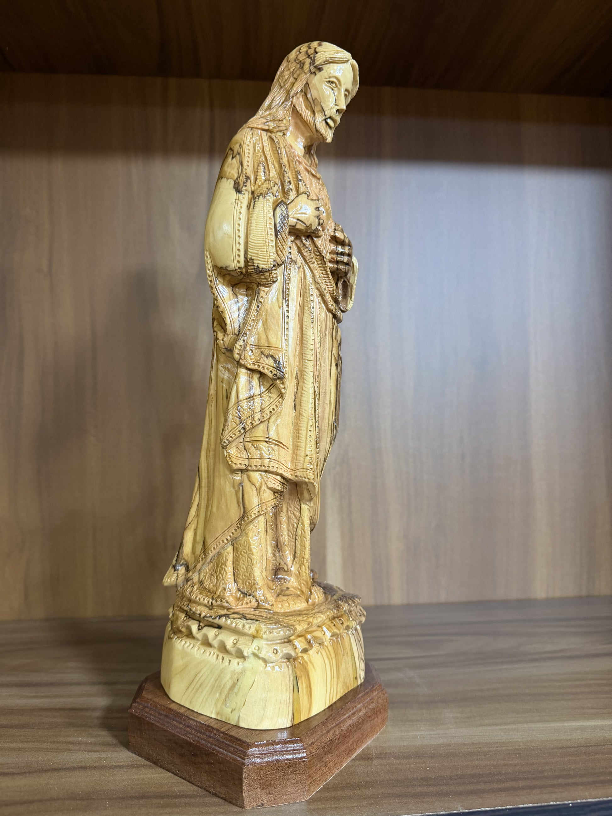 Close view of the carved Sacred Heart and hands on the Jesus statue
