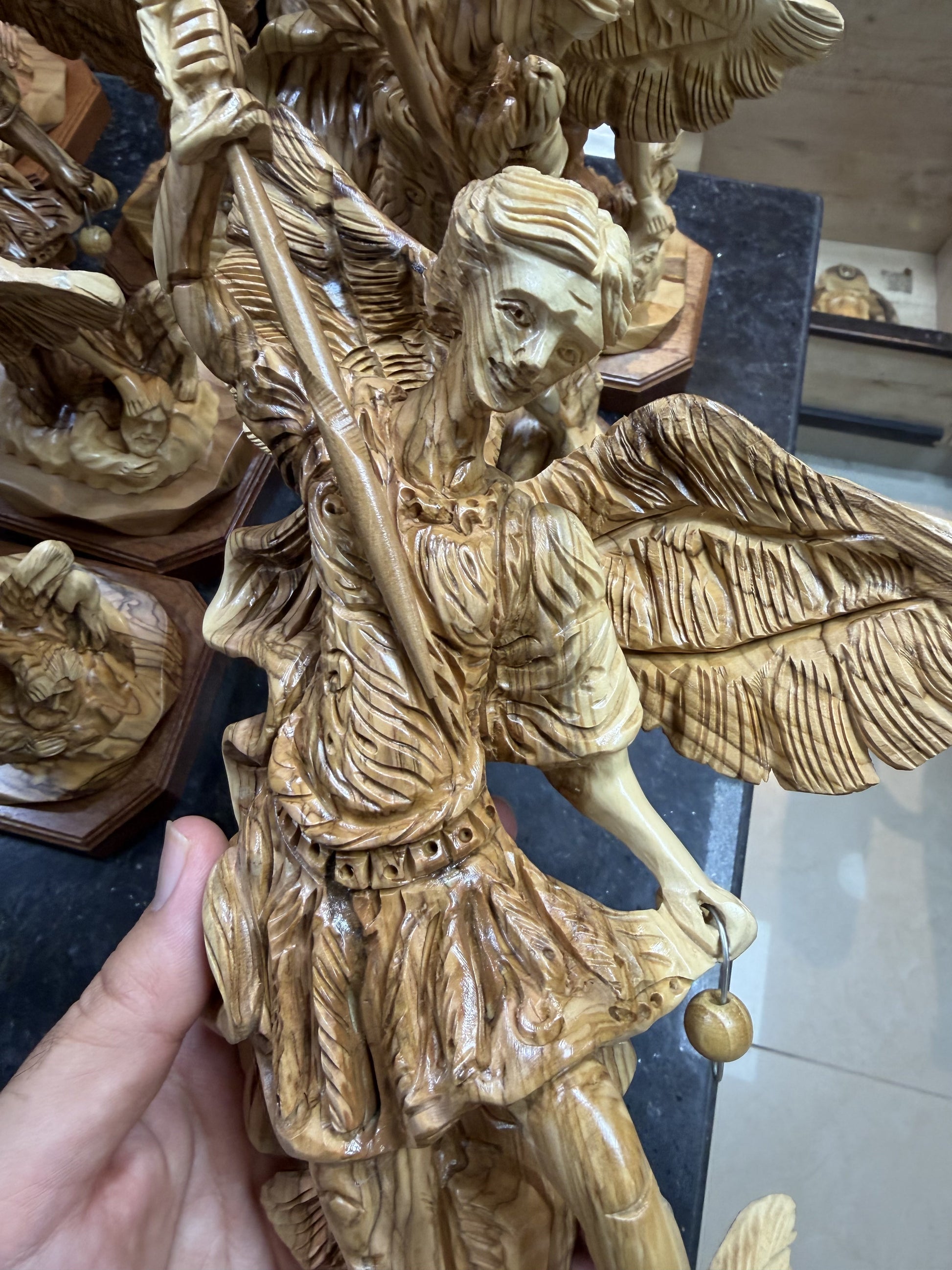 Real close photograph of the St. Michael statue face, armor, spear and carved olive wood grain