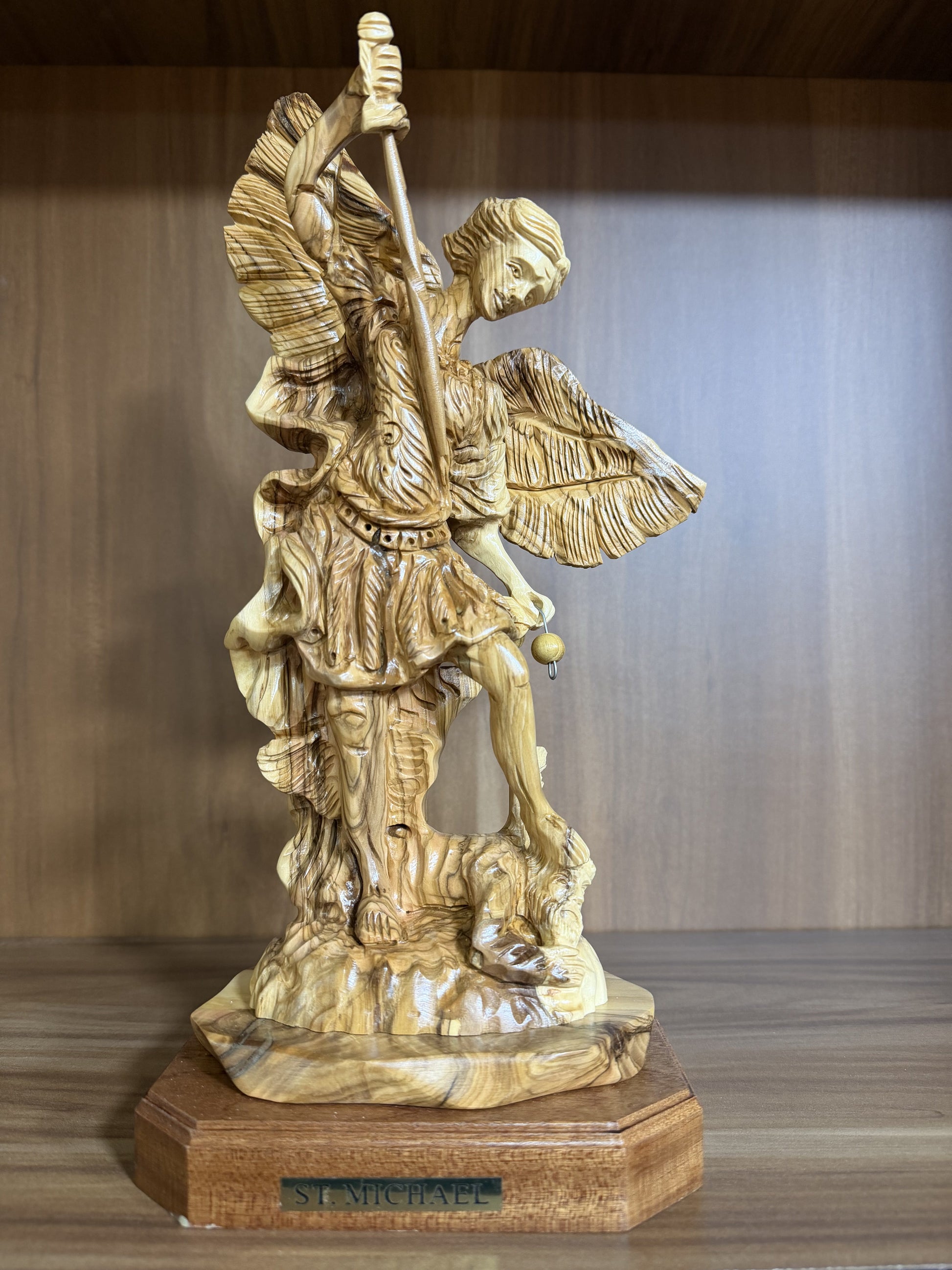 Real front photograph of the St. Michael Archangel olive wood statue on its engraved wooden base